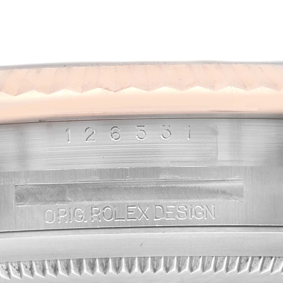 This image shows a close-up of the edge and side of a Rolex Datejust 41 126331 Men's Steel and Gold (two tone) Pink Dial 126331 Men's Steel and Gold (two tone) Pink Dial model, featuring part of the bezel and engravings.