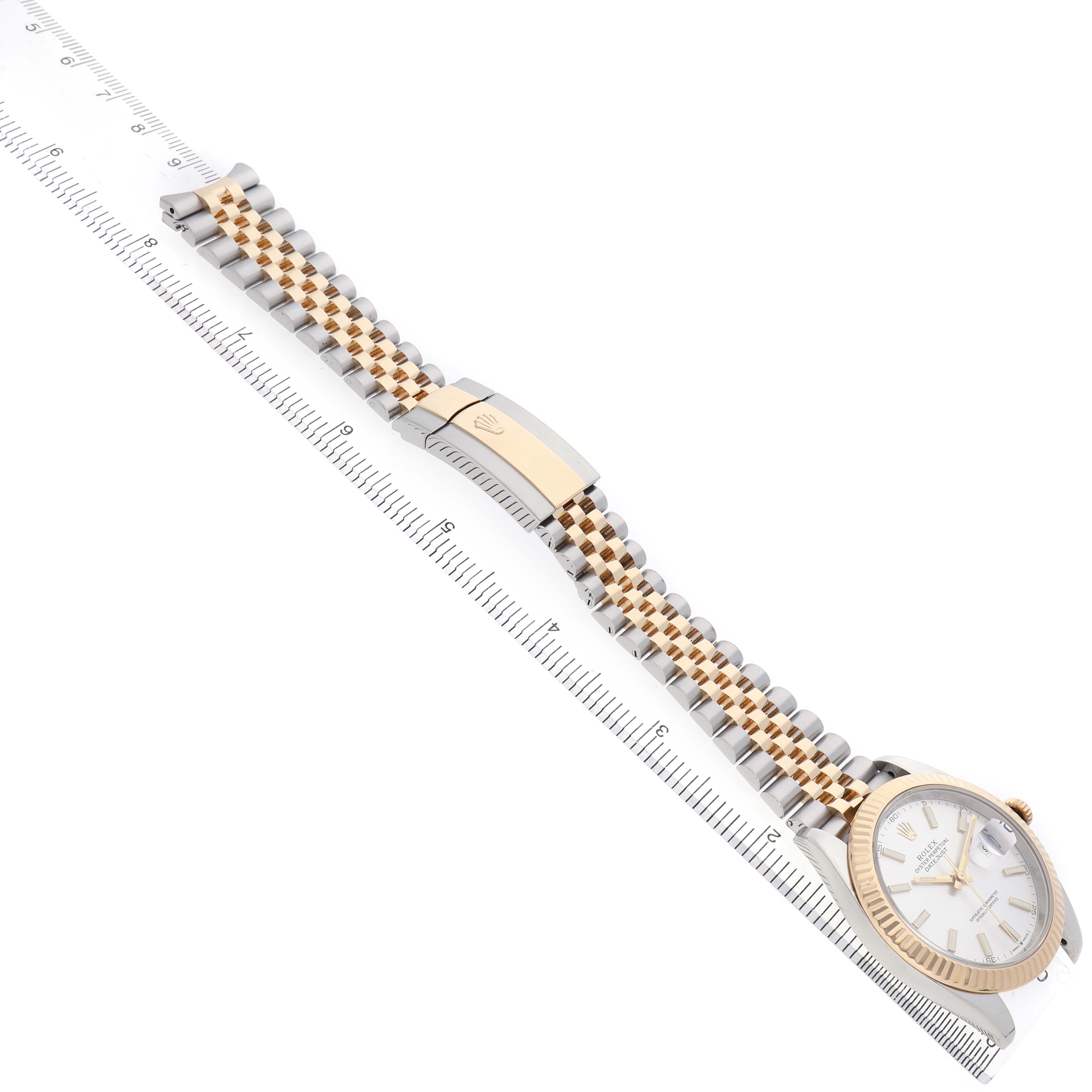 The Rolex Datejust 41 126333 Men's Steel and Gold (two tone) Silver Dial watch is shown at a diagonal angle displaying the face, bezel, and Jubilee bracelet alongside a ruler.