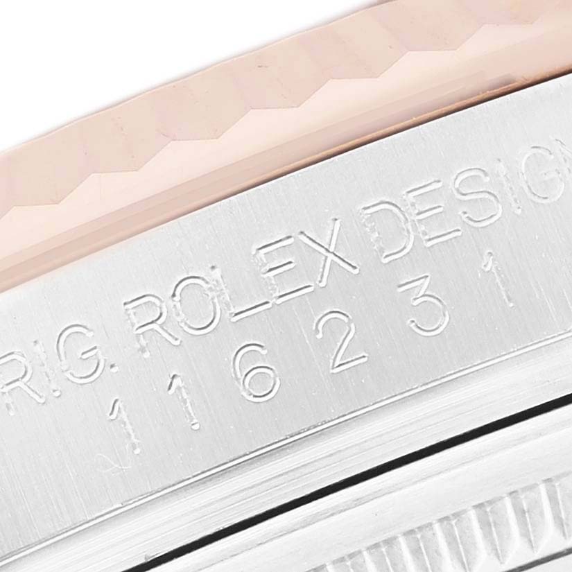 The image shows a close-up of the Rolex Datejust 116231 Men's Steel and Gold (two tone) Black Dial model's bezel with engraved lettering and part of the fluted edge.