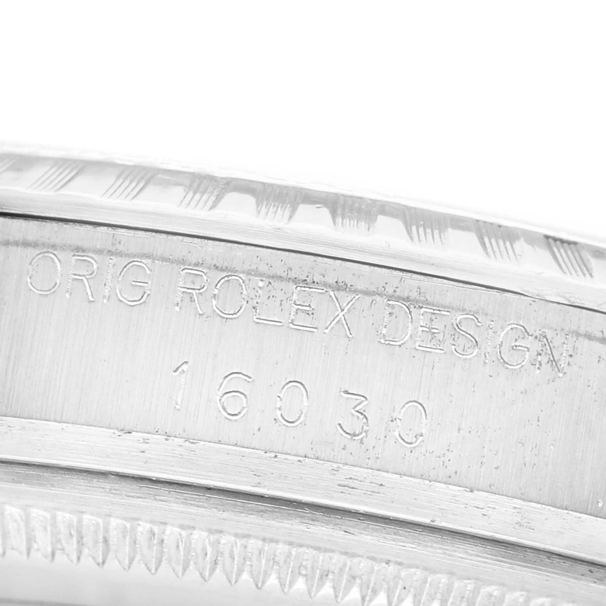 The image shows a close-up of the engraved side of a Rolex Datejust 16030 Men's Stainless Steel Silver Dial watch, focusing on the model number and brand inscription.