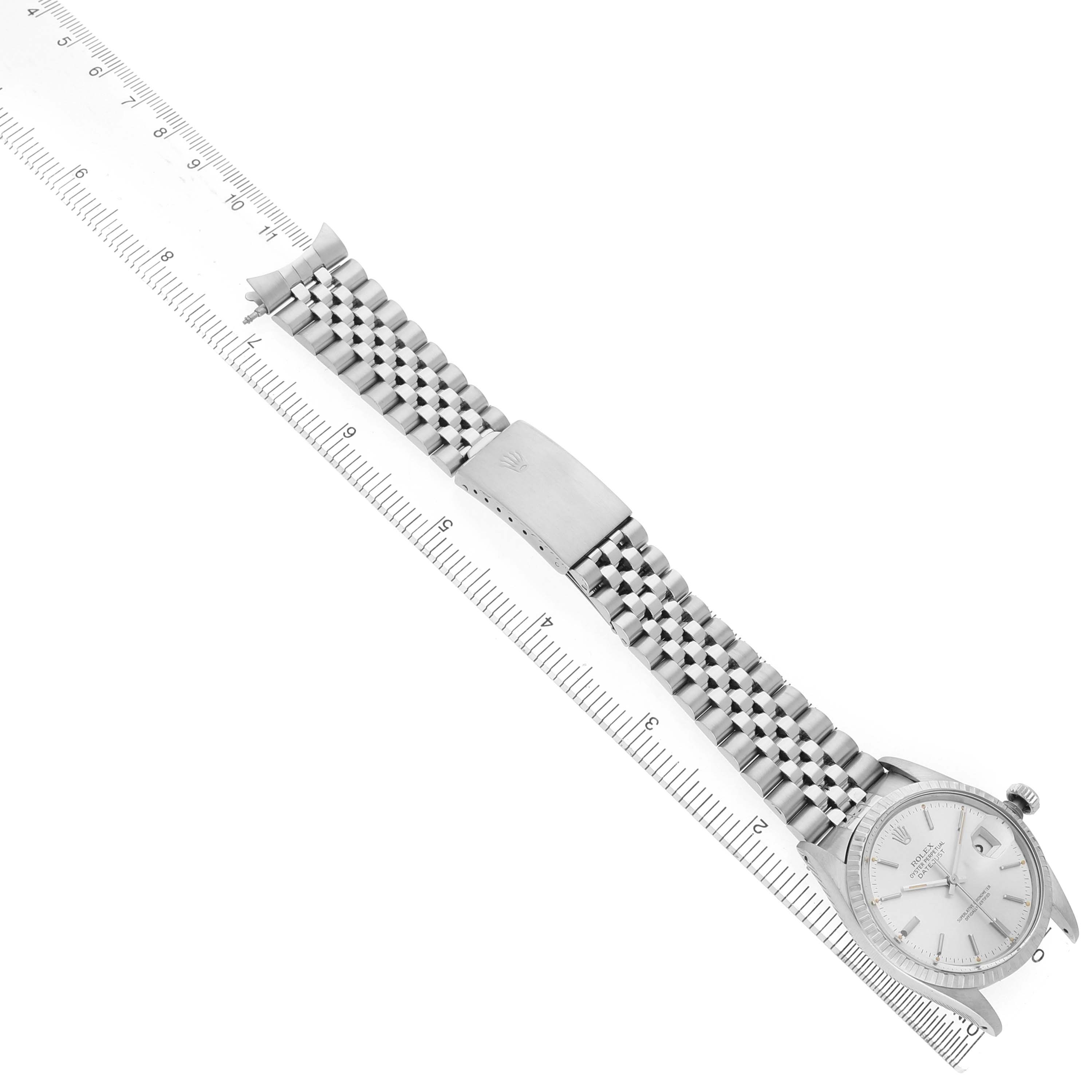 The Rolex Datejust 16030 Men's Stainless Steel Silver Dial watch is shown from an angled top view, displaying the dial, bracelet, clasp, and a ruler for scale.