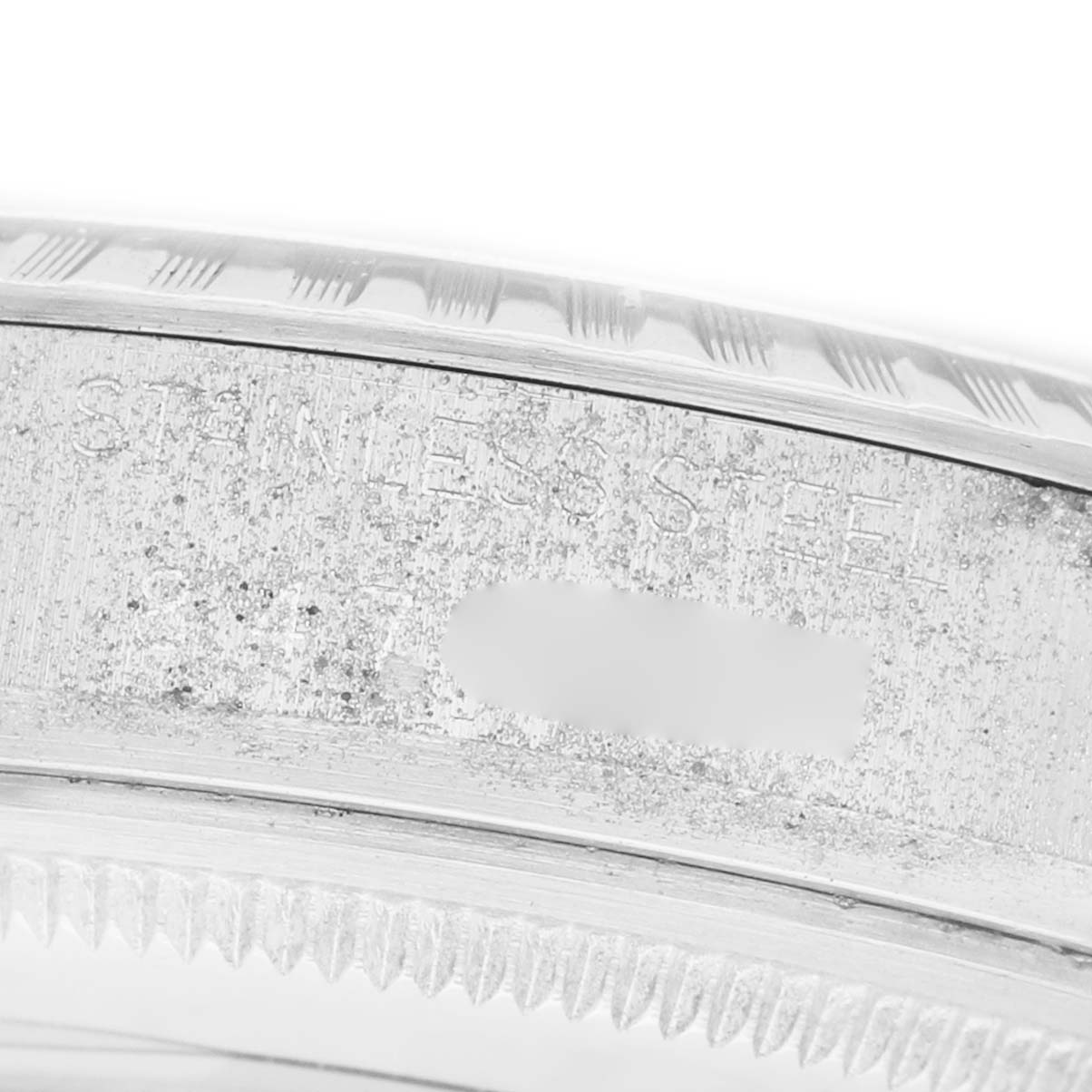 The image shows a close-up of the case side of a Rolex Datejust 16030 Men's Stainless Steel Silver Dial, highlighting its fluted bezel and "Stainless Steel" engraving.