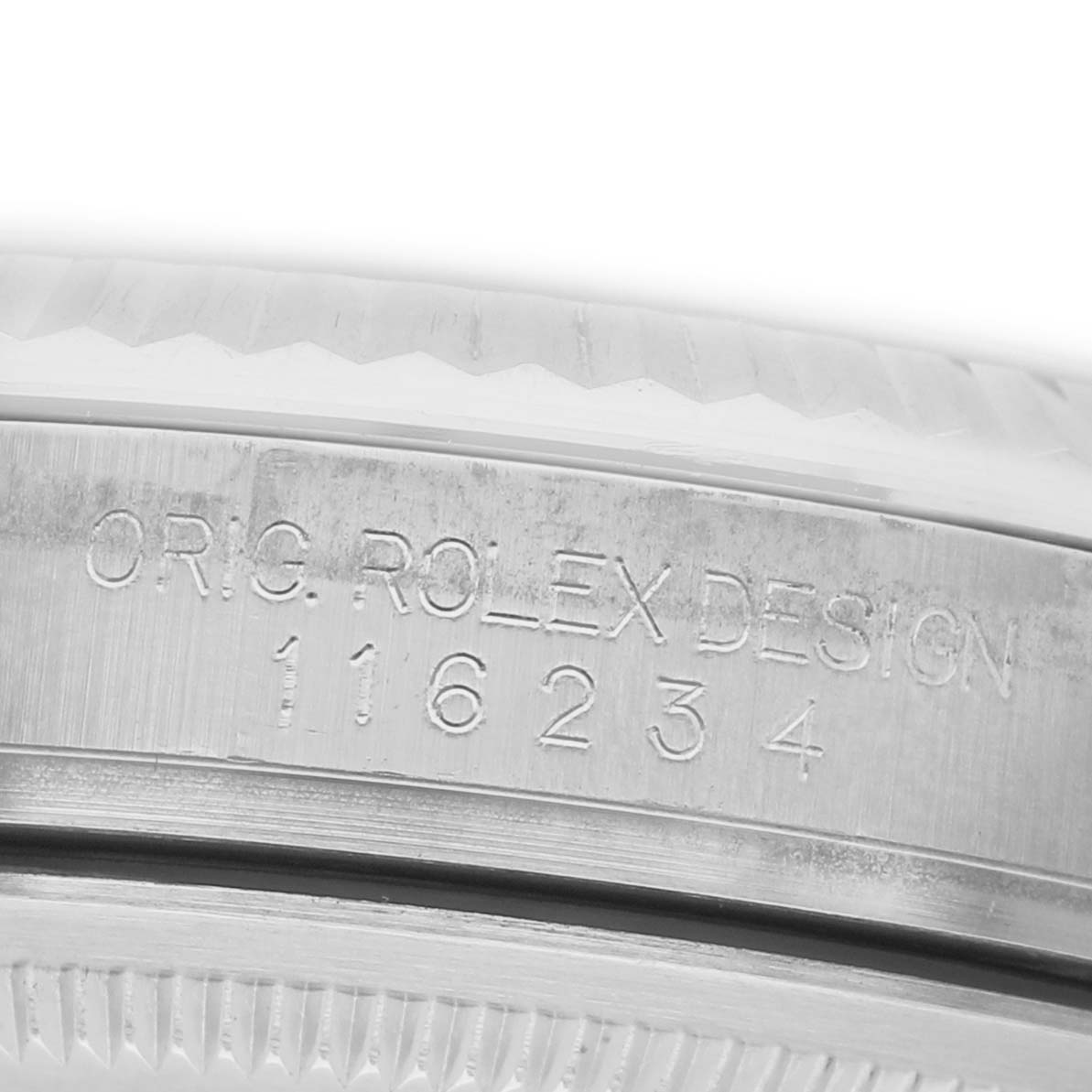 The image shows a close-up of the bezel and engraved serial number on a Rolex Datejust 116234 Men's Stainless Steel Blue Dial watch.