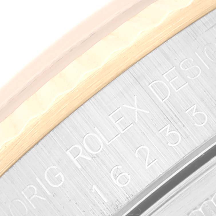 The image shows the inscribed rehaut of a Rolex Datejust 16233 Men's Steel and Gold (two tone) Black Dial 16233 Men's Steel and Gold (two tone) Black Dial watch at a close angle, highlighting parts of the model number and brand engraving.