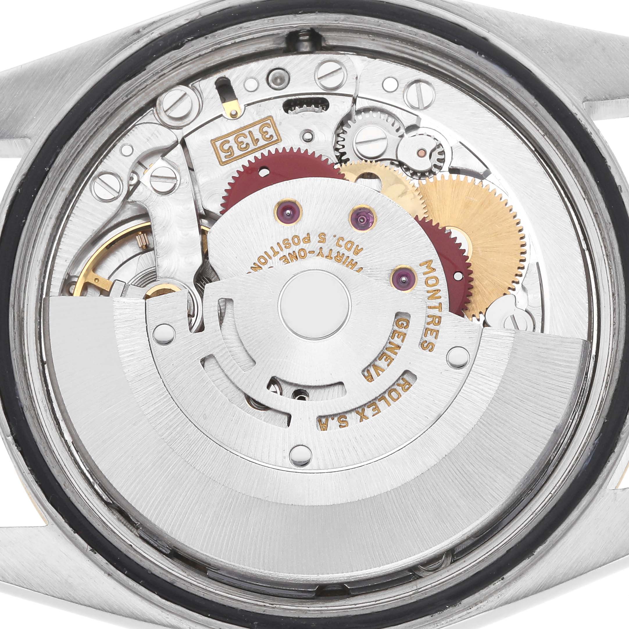 The image shows the movement of a Rolex Datejust model 16233 from the back, highlighting the intricate gears and rotor mechanism.