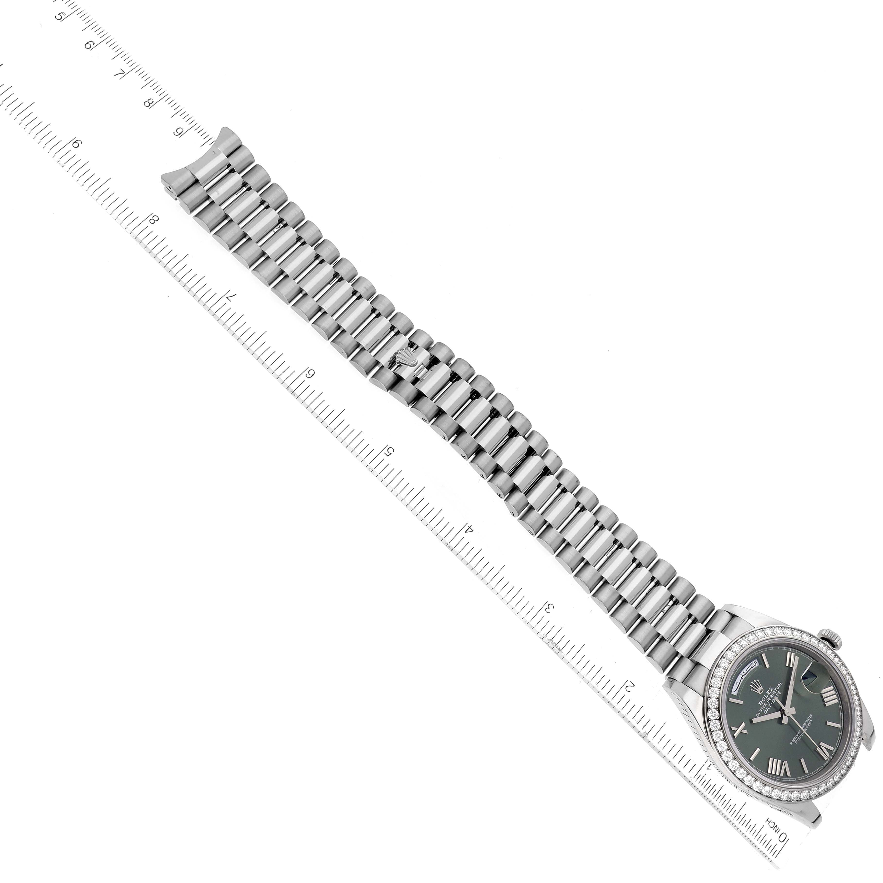 The image shows the Rolex President 228349 Men's White Gold Green Dial 228349 Men's White Gold Green Dial model watch laid flat at an angle, capturing the face and full bracelet alongside a ruler for scale.