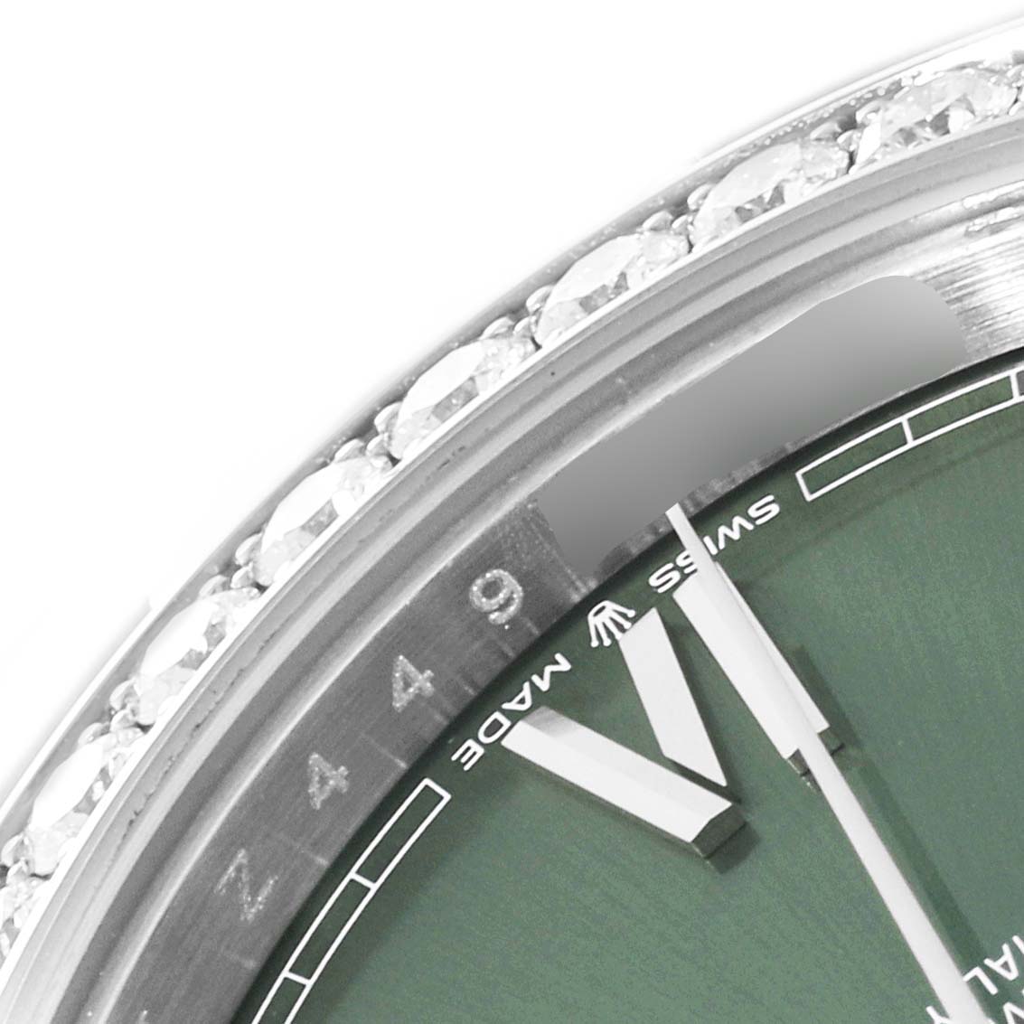 This close-up of the Rolex President 228349 Men's White Gold Green Dial 228349 Men's White Gold Green Dial model watch shows part of the dial, hands, and diamond-encrusted bezel.
