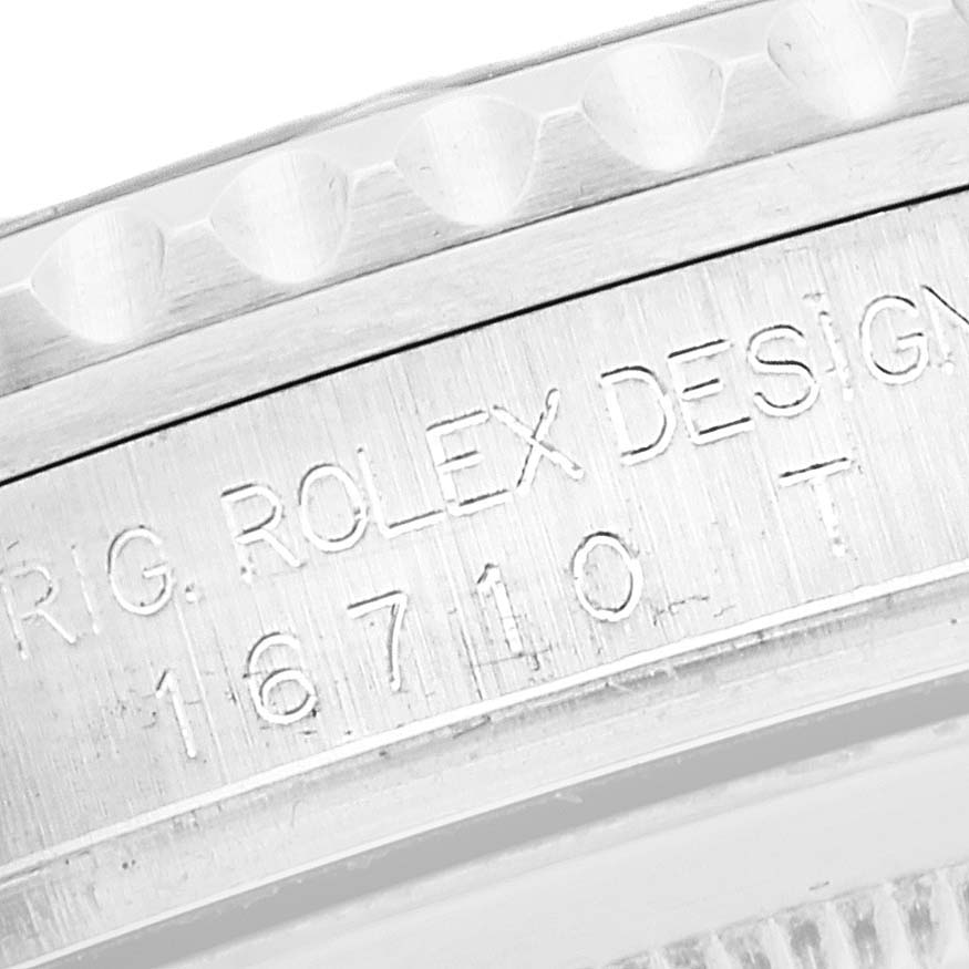 The image shows a close-up of the side of a Rolex GMT-Master 16710 Men's Stainless Steel Black Dial 16710 Men's Stainless Steel Black Dial watch, featuring engraved text and part of the bezel.