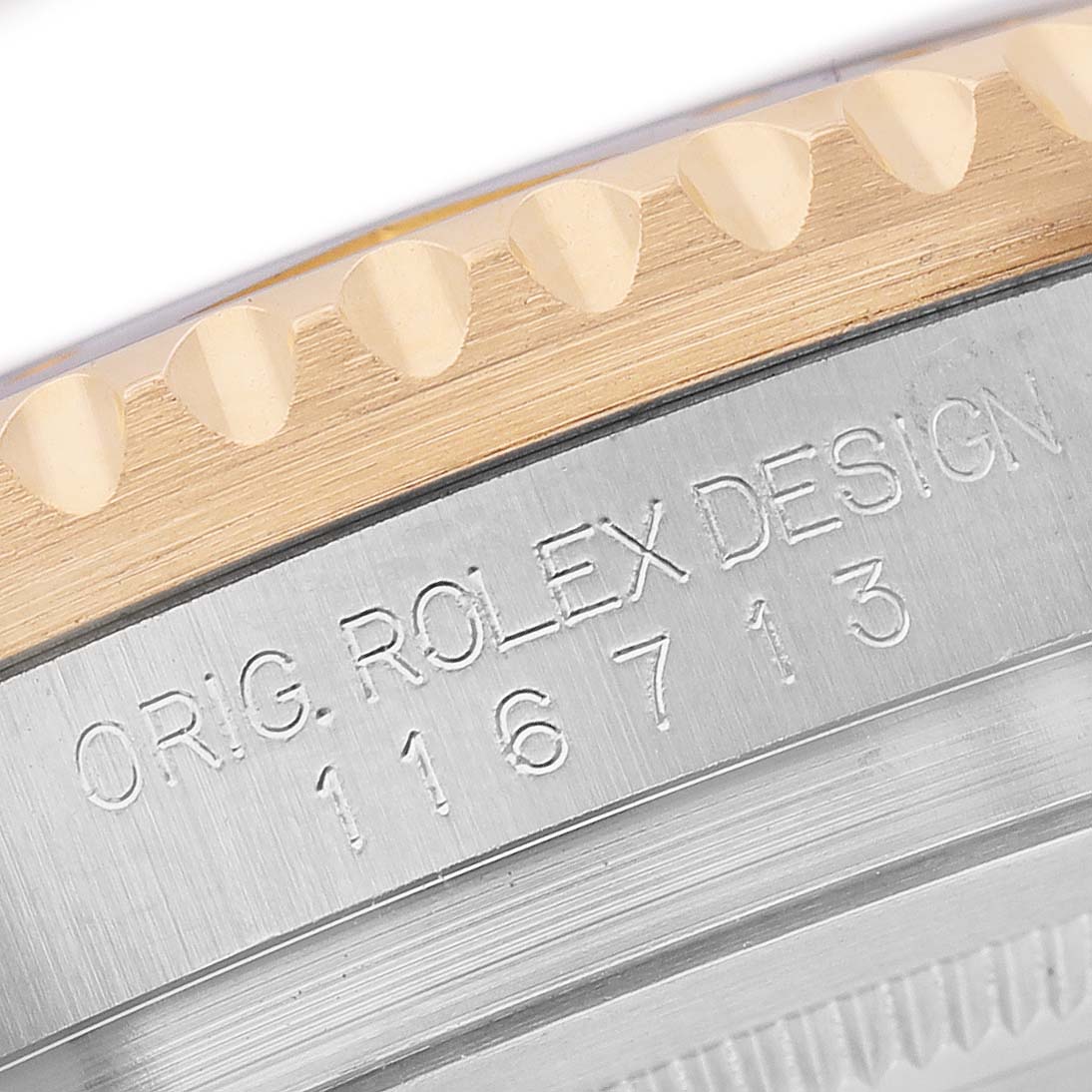 The image shows a close-up of the Rolex GMT-Master 116713LN Men's Steel and Gold (two tone) Black Dial model's bezel and engraved case number.