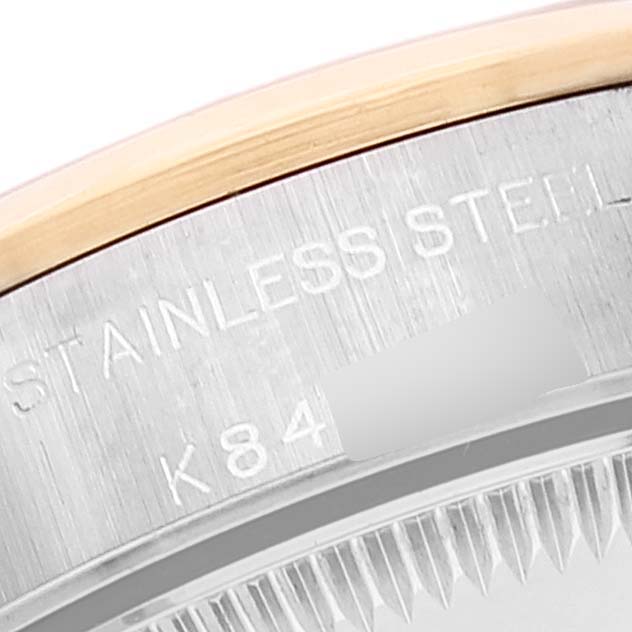 The image shows a close-up view of the case back edge of a Rolex Oyster Perpetual 76183 Women's Steel and Gold (two tone) Grey Dial 76183 Women's Steel and Gold (two tone) Grey Dial, highlighting the stainless steel engraving.