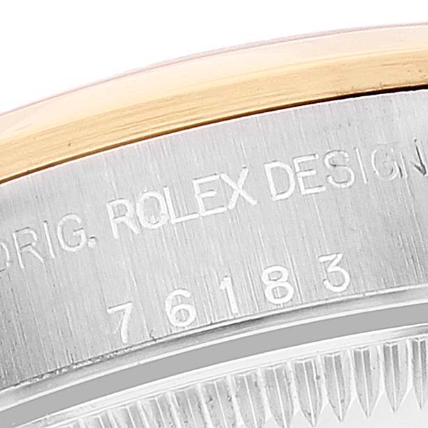This image shows a close-up of the engraved side of a Rolex Oyster Perpetual 76183 Women's Steel and Gold (two tone) Grey Dial 76183 Women's Steel and Gold (two tone) Grey Dial watch casing.