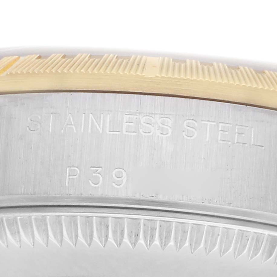The image shows a close-up of the side of a Rolex Oyster Perpetual model 76243, focusing on the stainless steel text and edge of the watch bezel.