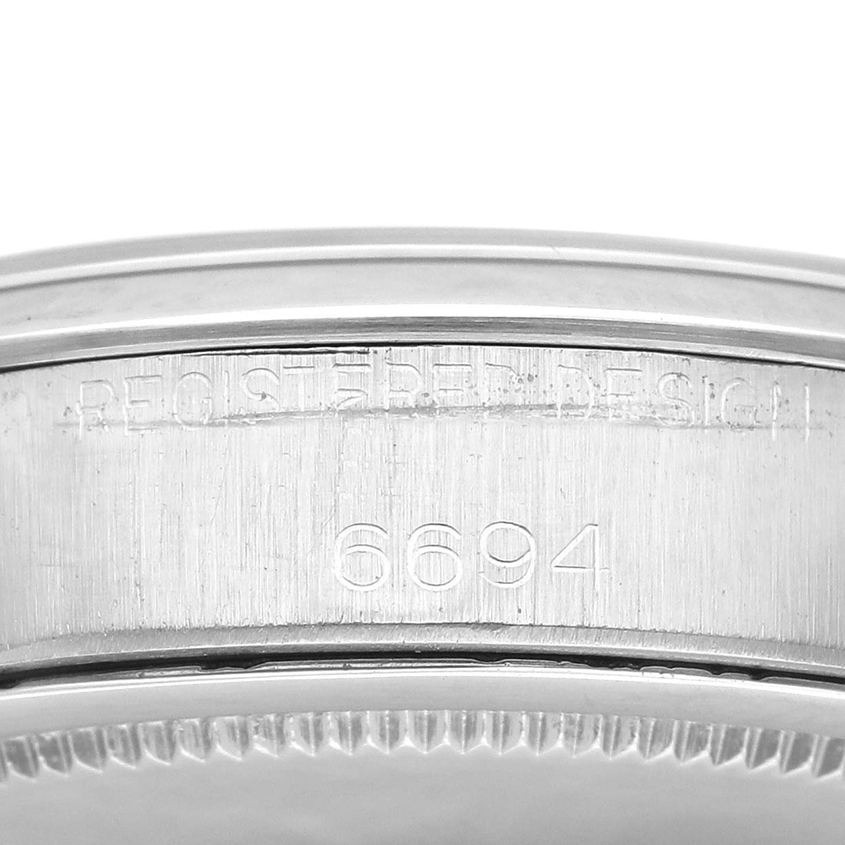 Close-up of the side of the Rolex Vintage Collection 6694 Men's Stainless Steel Silver Dial 6694 Men's Stainless Steel Silver Dial watch, showing the serial number "6694" and "REGISTERED DESIGN" engraving.