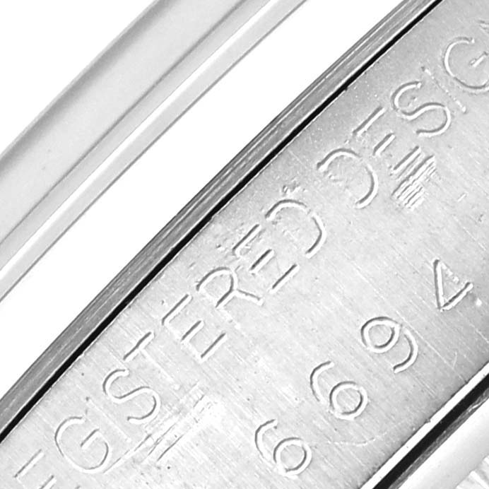 The image shows an engraved part of the Rolex Vintage Collection 6694 Men's Stainless Steel Silver Dial 6694 Men's Stainless Steel Silver Dial watch, focusing on the case's side with engravings.