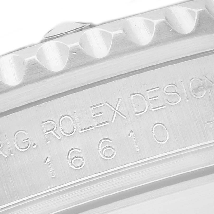 The image shows a close-up of the case engraving on a Rolex Submariner model 16610, highlighting the model number and design details.