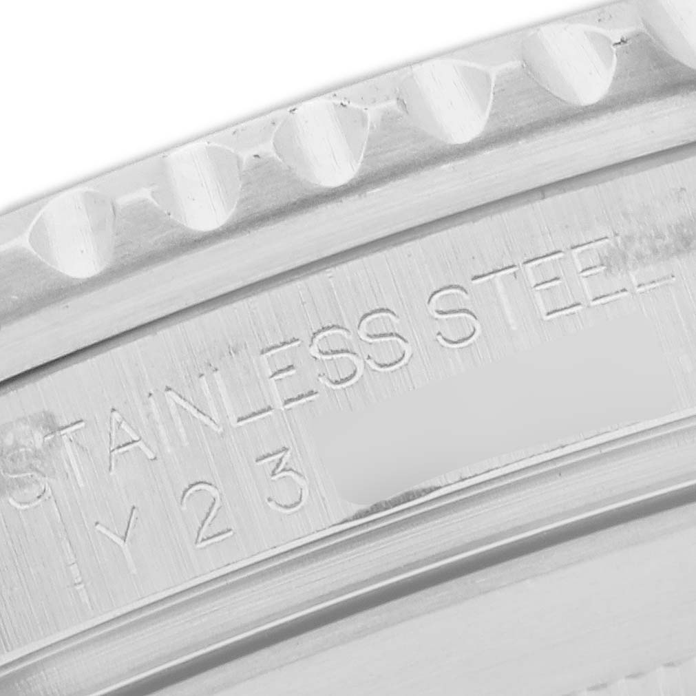 The image shows a close-up of the engraving on the bezel area of a Rolex Submariner, model 16610, highlighting the "STAINLESS STEEL" marking.