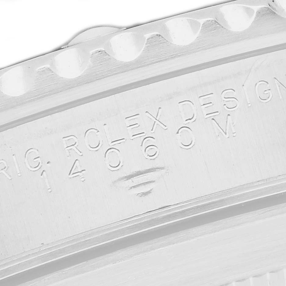 The image shows a close-up of the edge and engraving on the case back of a Rolex Submariner model 14060M.
