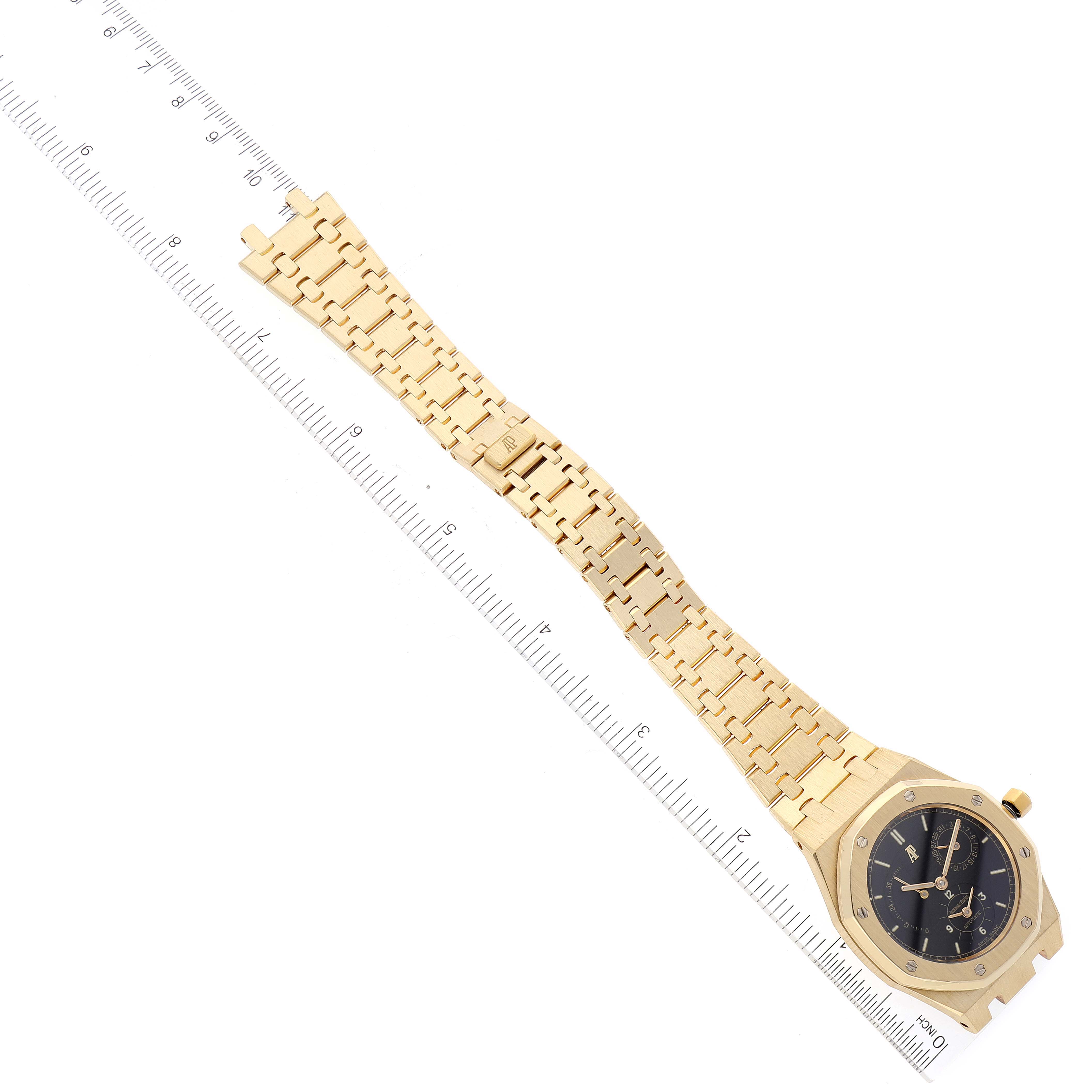 The image shows an Audemars Piguet Royal Oak 25730BA Men's Yellow Gold Black Dial 25730BA Men's Yellow Gold Black Dial watch at an overhead angle displaying the face, bracelet, and a ruler for scale.