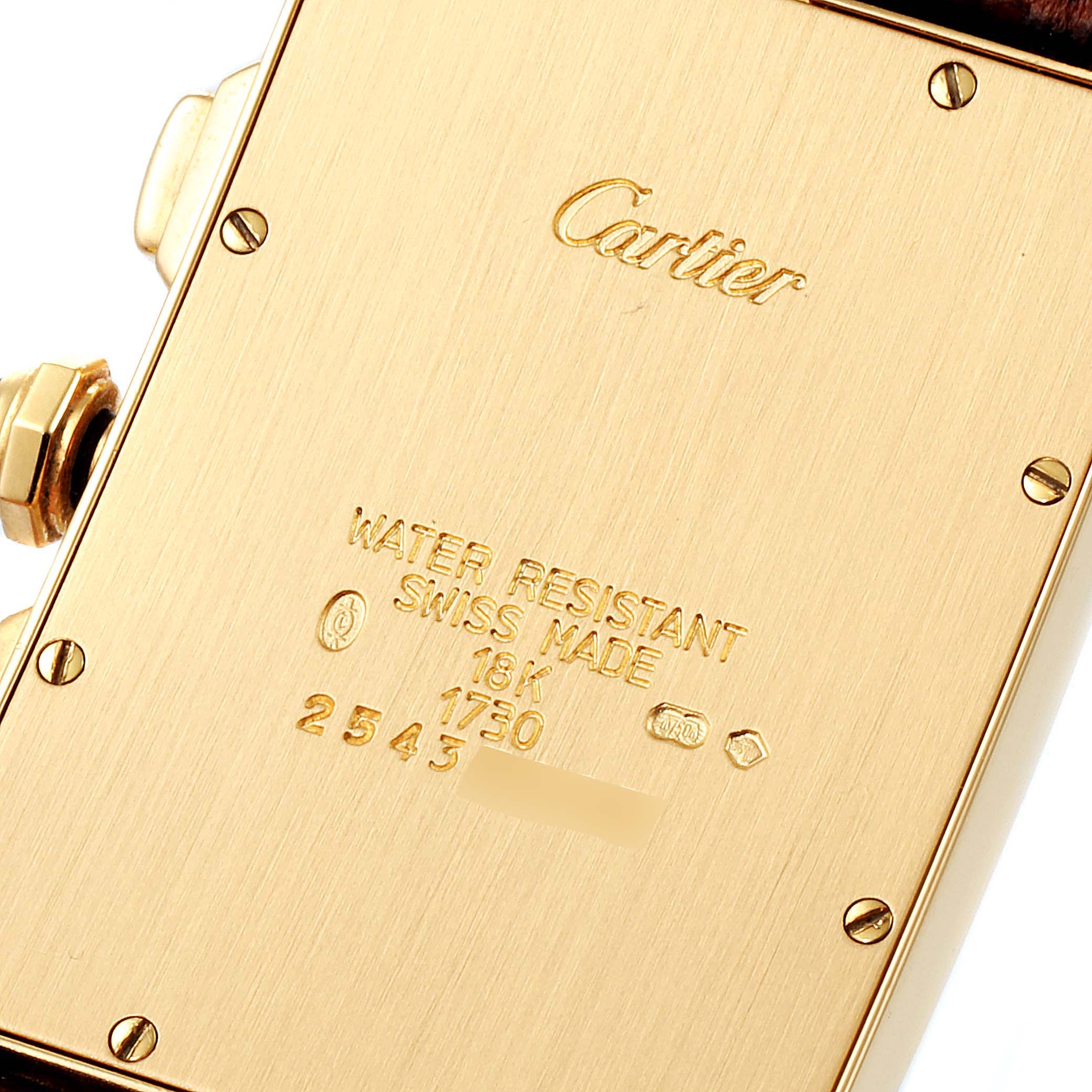 This image shows the back case of a Cartier Tank Americaine W2601156 Men's Yellow Gold Silver Dial W2601156 Men's Yellow Gold Silver Dial watch, highlighting the brand engraving and model details.