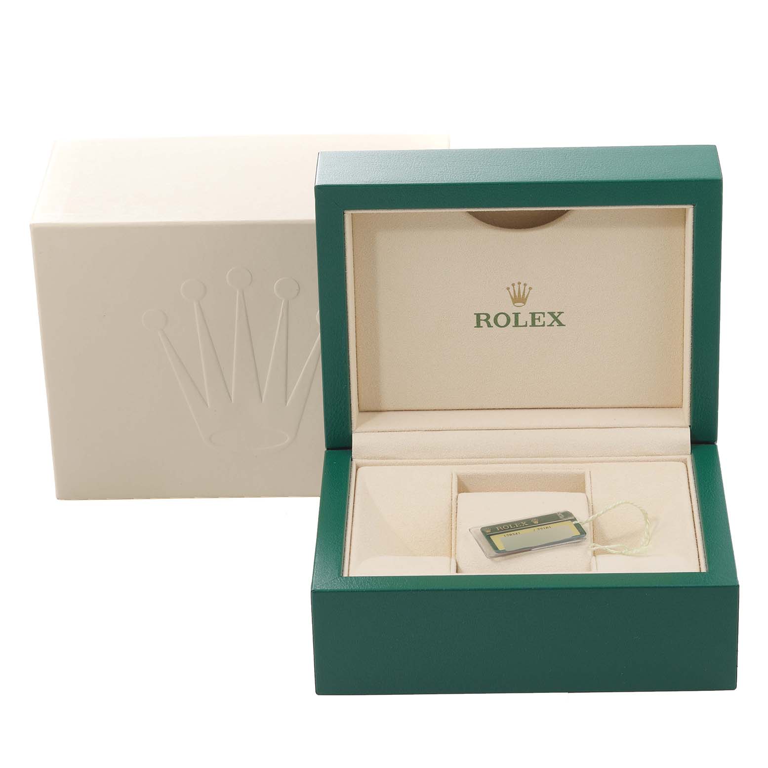 The image shows the open green and beige box of a mid-size Rolex model with a tag inside, all taken from a front angle.