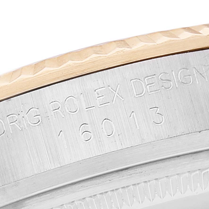 The image shows a close-up of the bezel and case edge of a Rolex Vintage Collection 16013 Men
s Steel and Gold (two tone) Silver Dial 16013 Men
s Steel and Gold (two tone) Silver Dial model with engraved text and a design number.