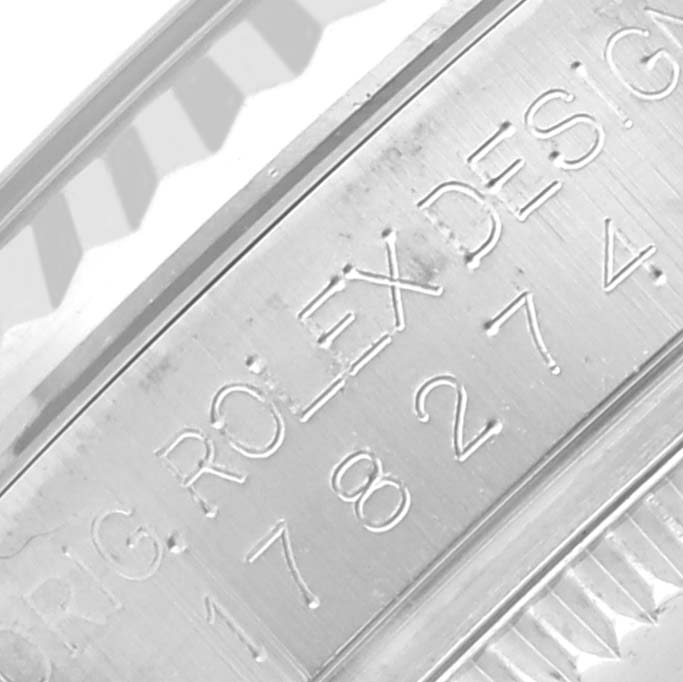 This image shows the engraved side of the bezel of a Mid-Size Rolex model watch, focusing on the design details and serial number.