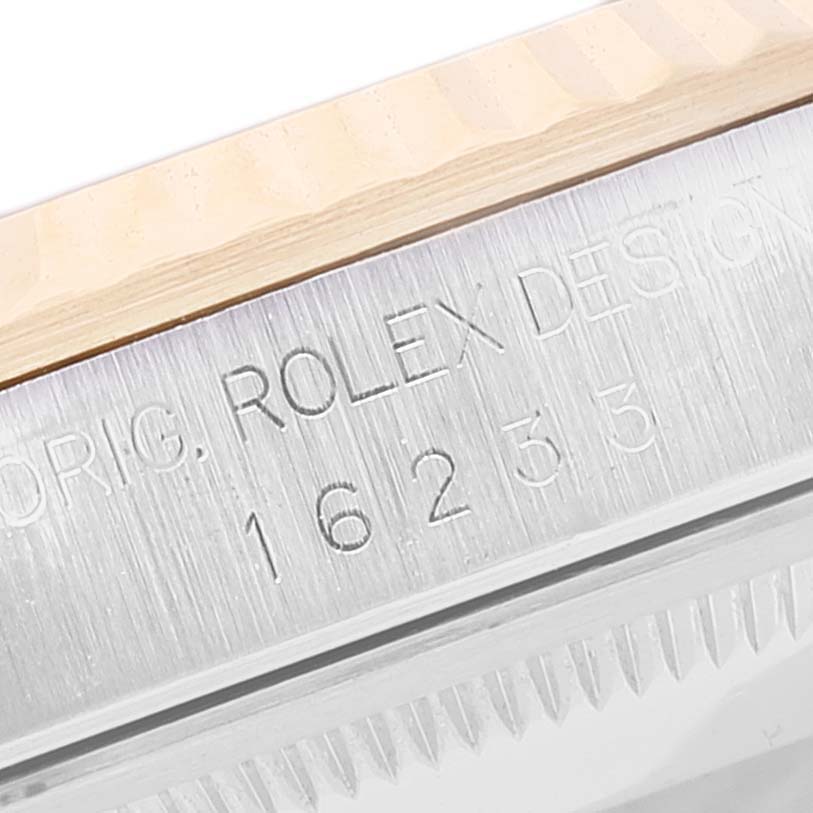 Close-up of the Rolex Datejust 16233 Men's Steel and Gold (two tone) Silver Dial 16233 Men's Steel and Gold (two tone) Silver Dial model showing part of the bezel and case with engraved text and reference number.