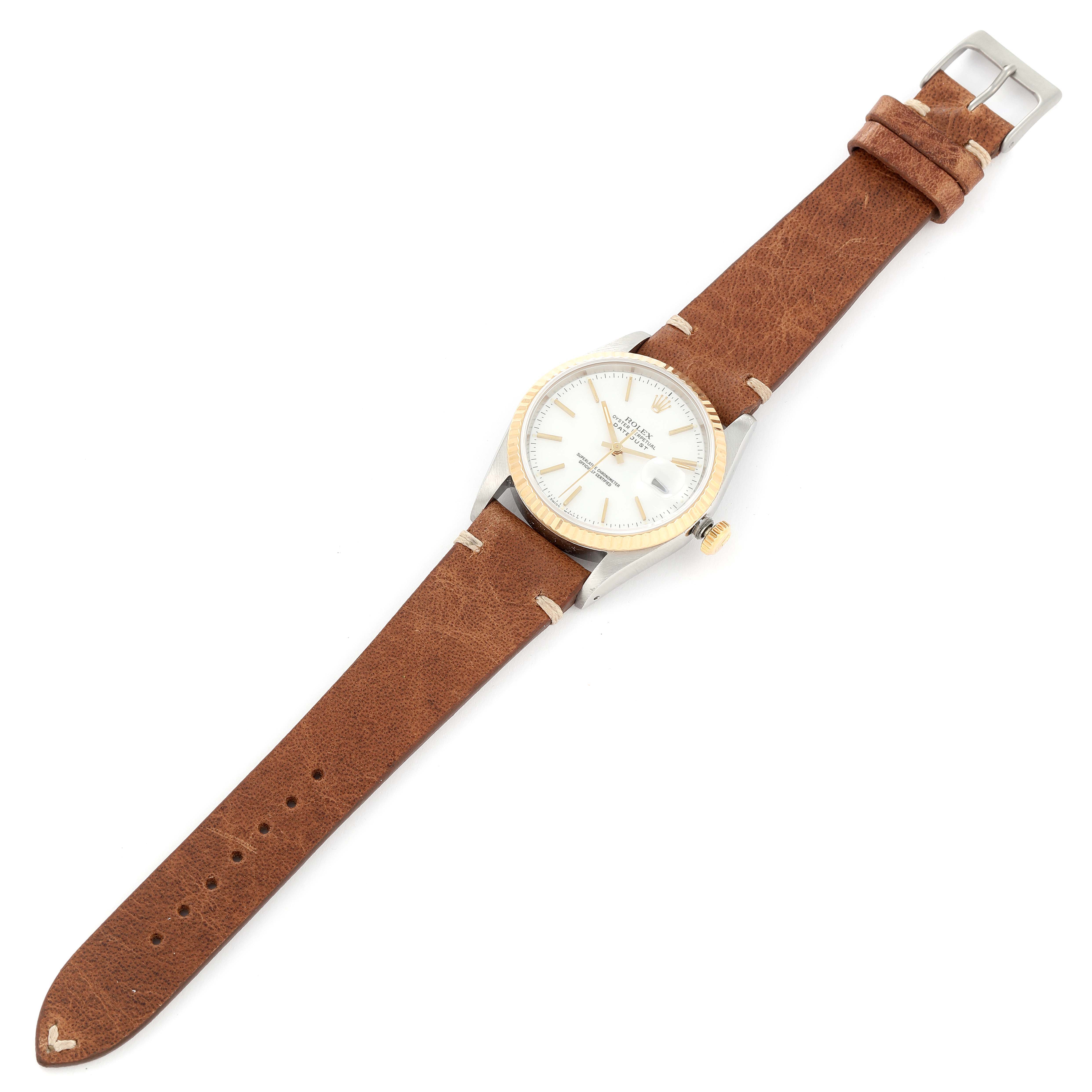 The Rolex Datejust 16233 Men's Steel and Gold (two tone) White Dial 16233 Men's Steel and Gold (two tone) White Dial watch is shown from a top view, displaying its face, case, crown, and brown leather strap.