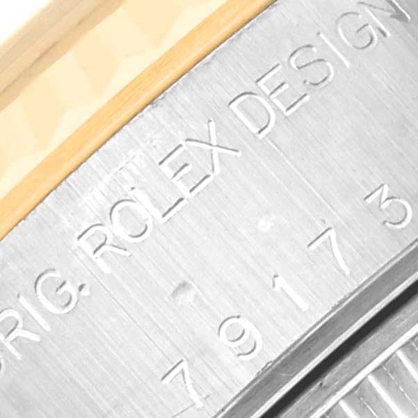 Close-up of a Rolex Datejust 79173 Women's Steel and Gold (two tone) Blue Dial 79173 Women's Steel and Gold (two tone) Blue Dial showing part of the bezel and engraved serial number on the case.