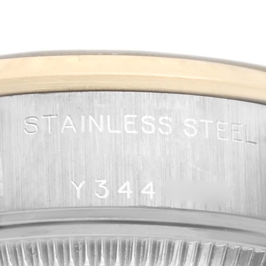 This close-up image shows the side of the bezel and part of the stainless steel casing with engraved text and serial number of a Rolex Datejust 79163 Women's Steel and Gold (two tone) Grey Dial 79163 Women's Steel and Gold (two tone) Grey Dial watch.
