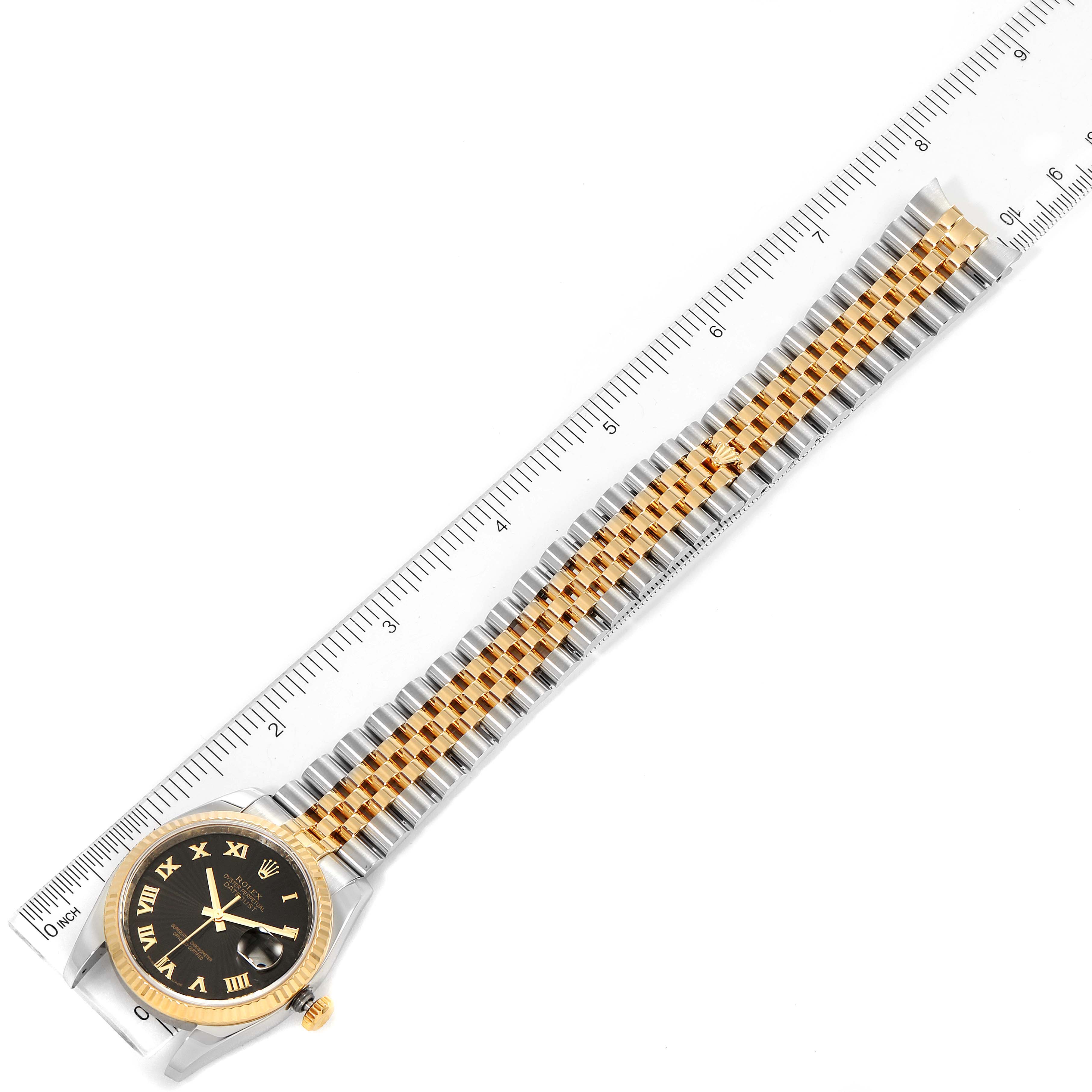 The image shows a Rolex Datejust 116233 Men's Steel and Gold (two tone) Black Dial 116233 Men's Steel and Gold (two tone) Black Dial watch laid flat with the bracelet fully extended alongside a ruler for scale.