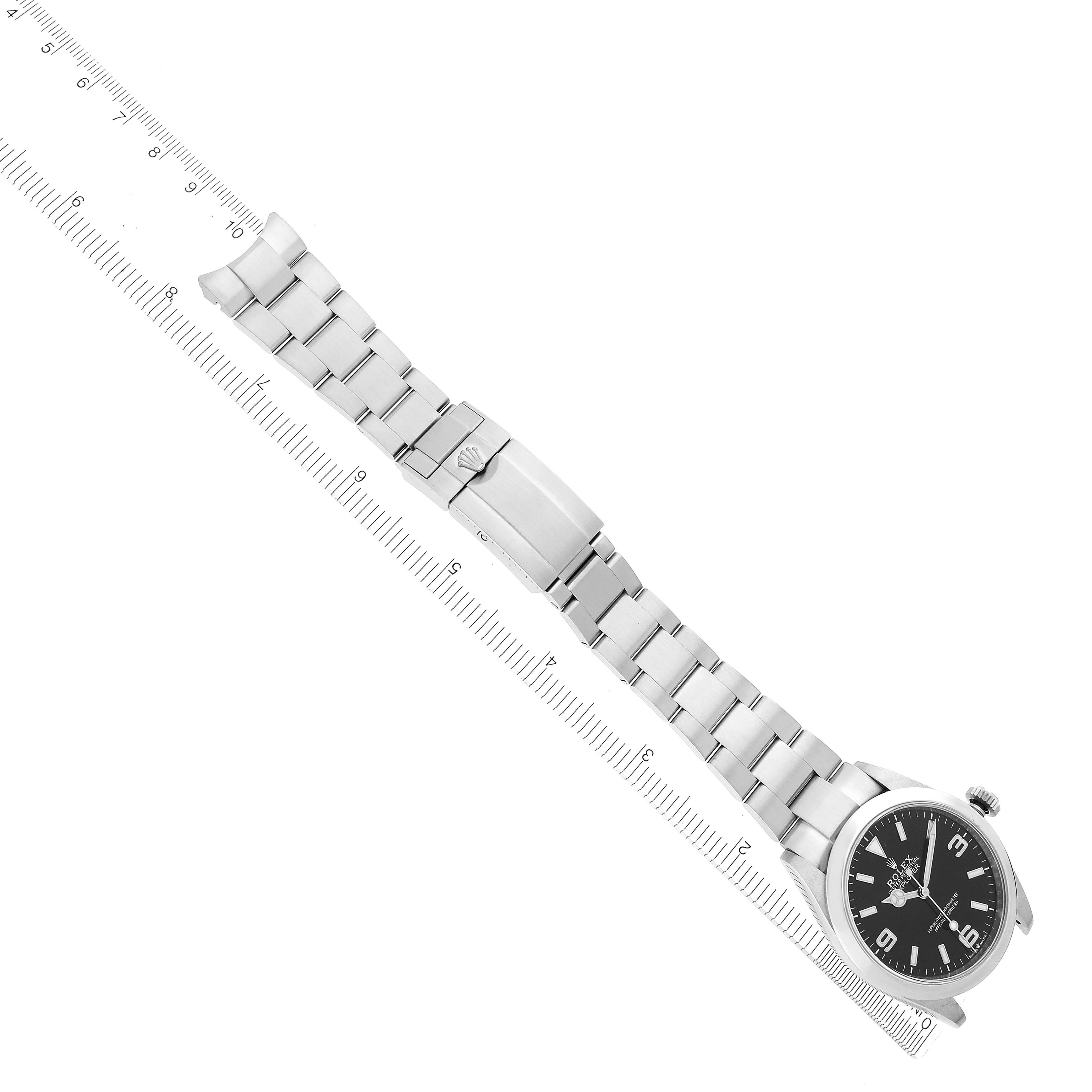 The Rolex Explorer model 224270 is shown at an angled top-down view, displaying the entire bracelet, clasp, and part of the dial with a ruler for scale.
