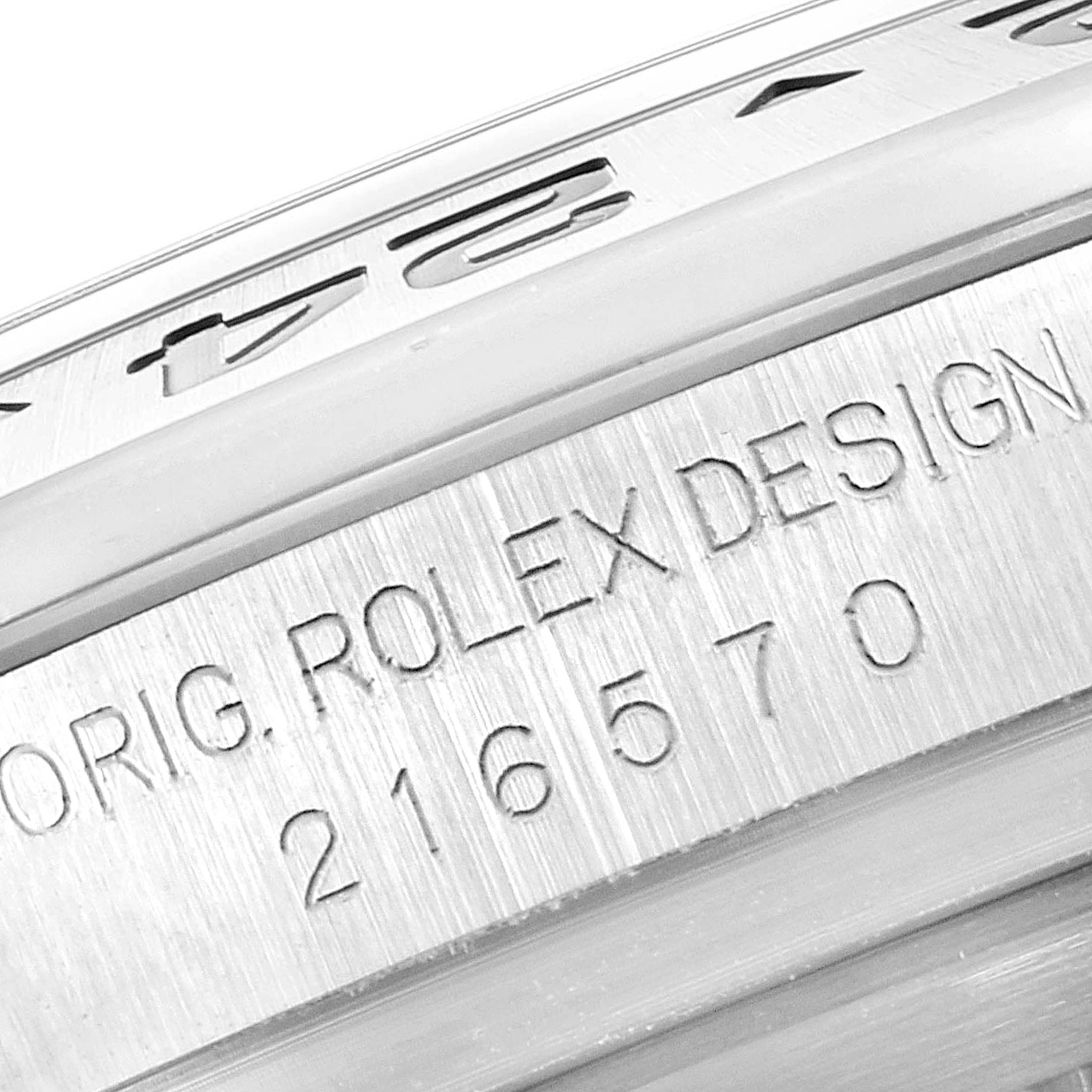 The image shows a close-up of the case side of the Rolex Explorer 216570 Men's Stainless Steel Black Dial 216570 Men's Stainless Steel Black Dial, displaying the model number 216570 and "ORIG. ROLEX DESIGN."