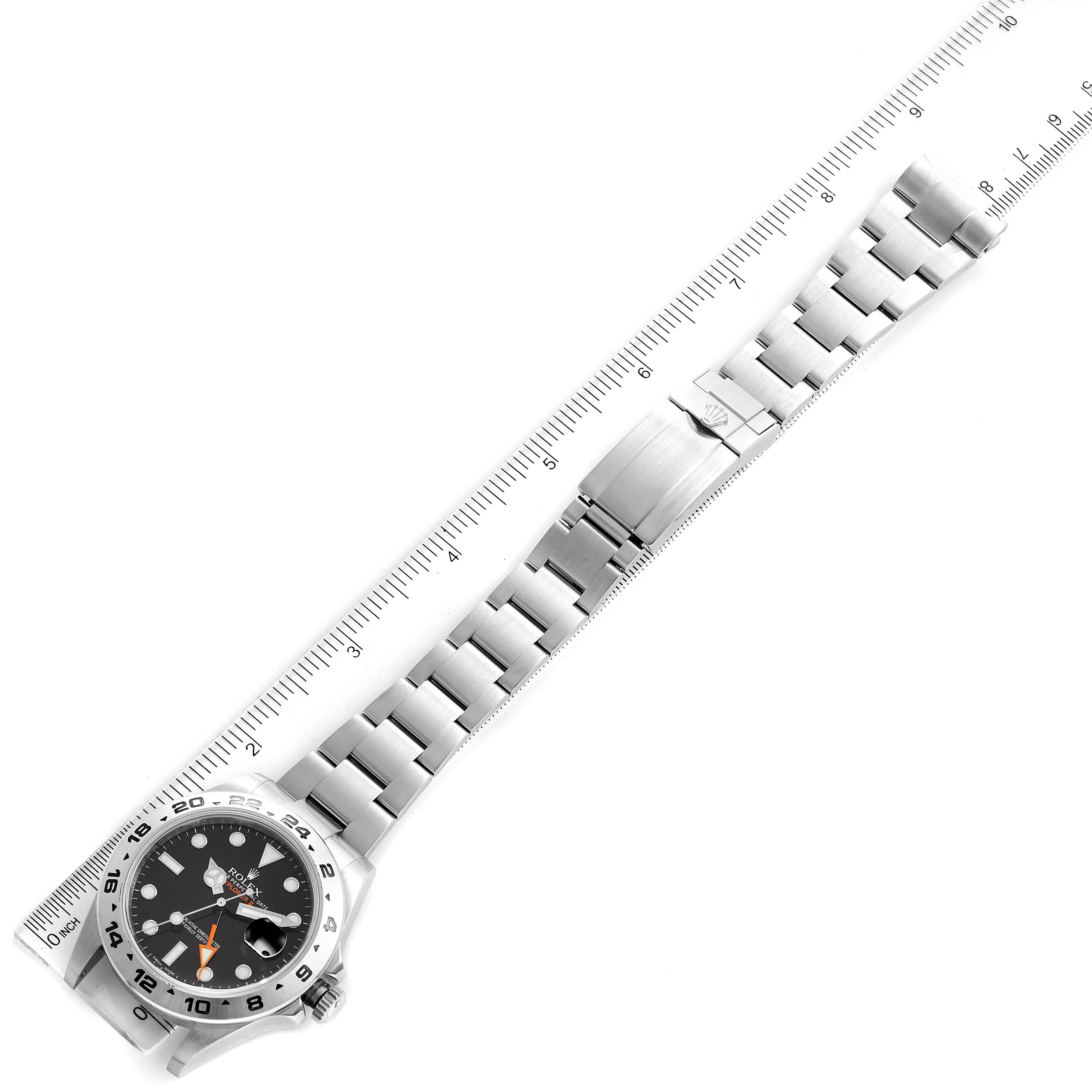 The image shows a top-down view of the Rolex Explorer 216570 Men's Stainless Steel Black Dial 216570 Men's Stainless Steel Black Dial watch, highlighting the face, bezel, and metal bracelet alongside a ruler for scale.