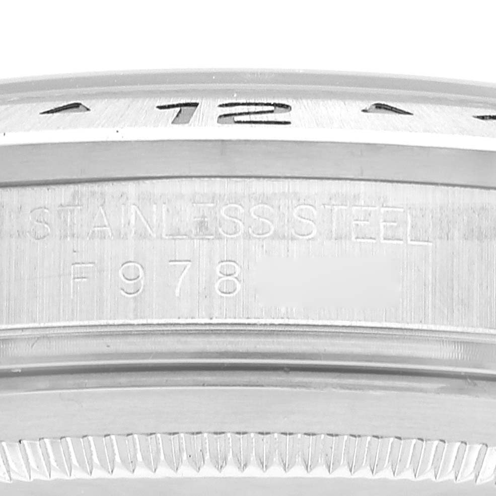 The image shows a close-up of the side of a Rolex Explorer 16570 Men's Stainless Steel Black Dial 16570 Men's Stainless Steel Black Dial watch, highlighting the stainless steel material and part of the engraved serial number.