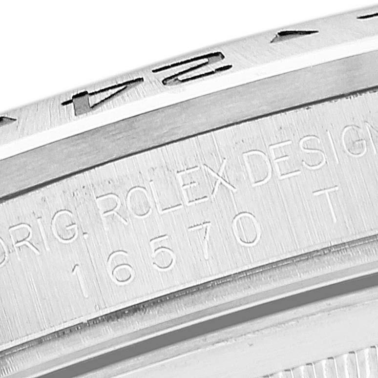 The image shows a close-up of a Rolex Explorer 16570 Men's Stainless Steel Black Dial 16570 Men's Stainless Steel Black Dial model's bezel and case, highlighting the engravings.