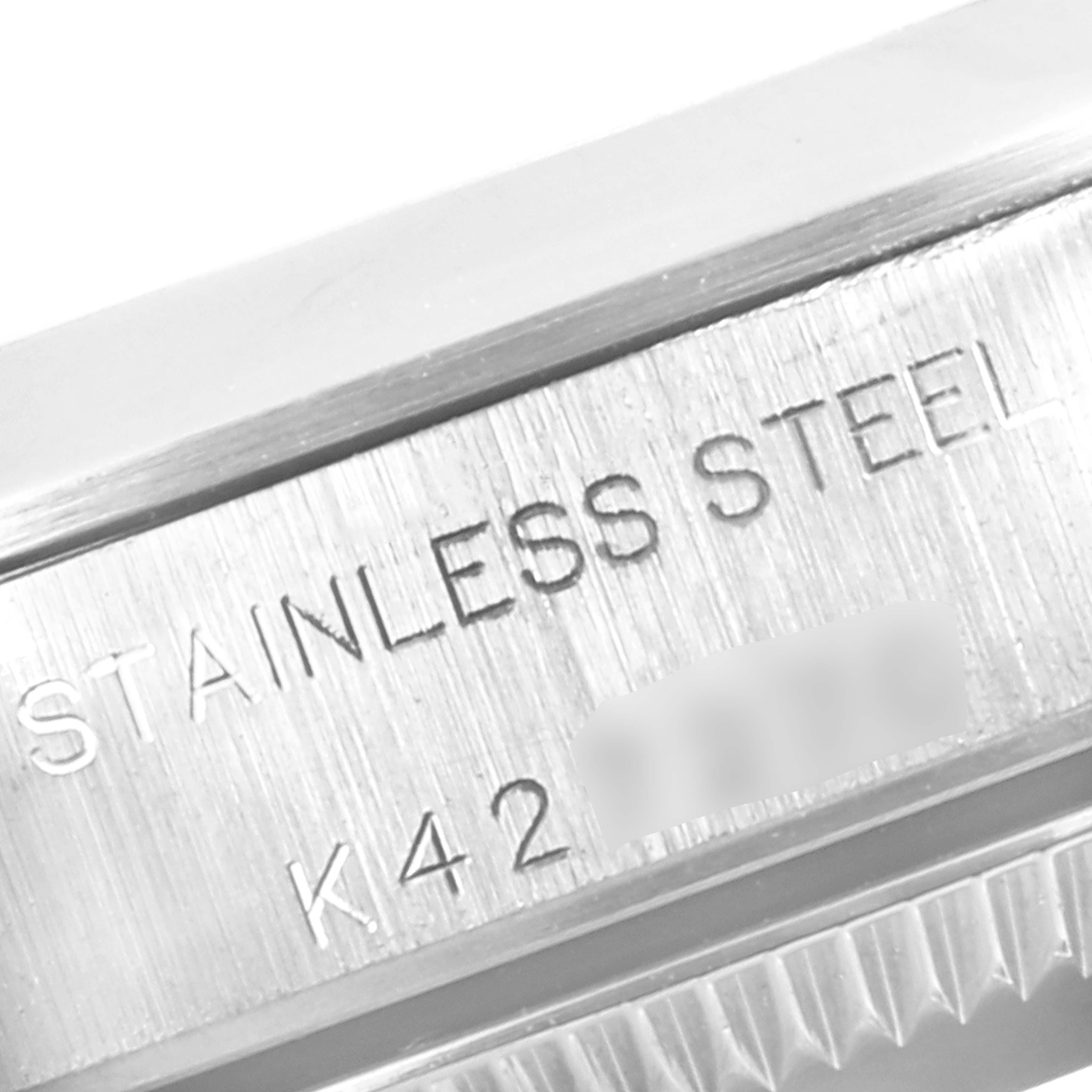 This image shows a close-up of the side of a Rolex Oyster Perpetual 76080 Women
s Stainless Steel Blue Dial 76080 Women
s Stainless Steel Blue Dial watch, highlighting the "STAINLESS STEEL" engraving.