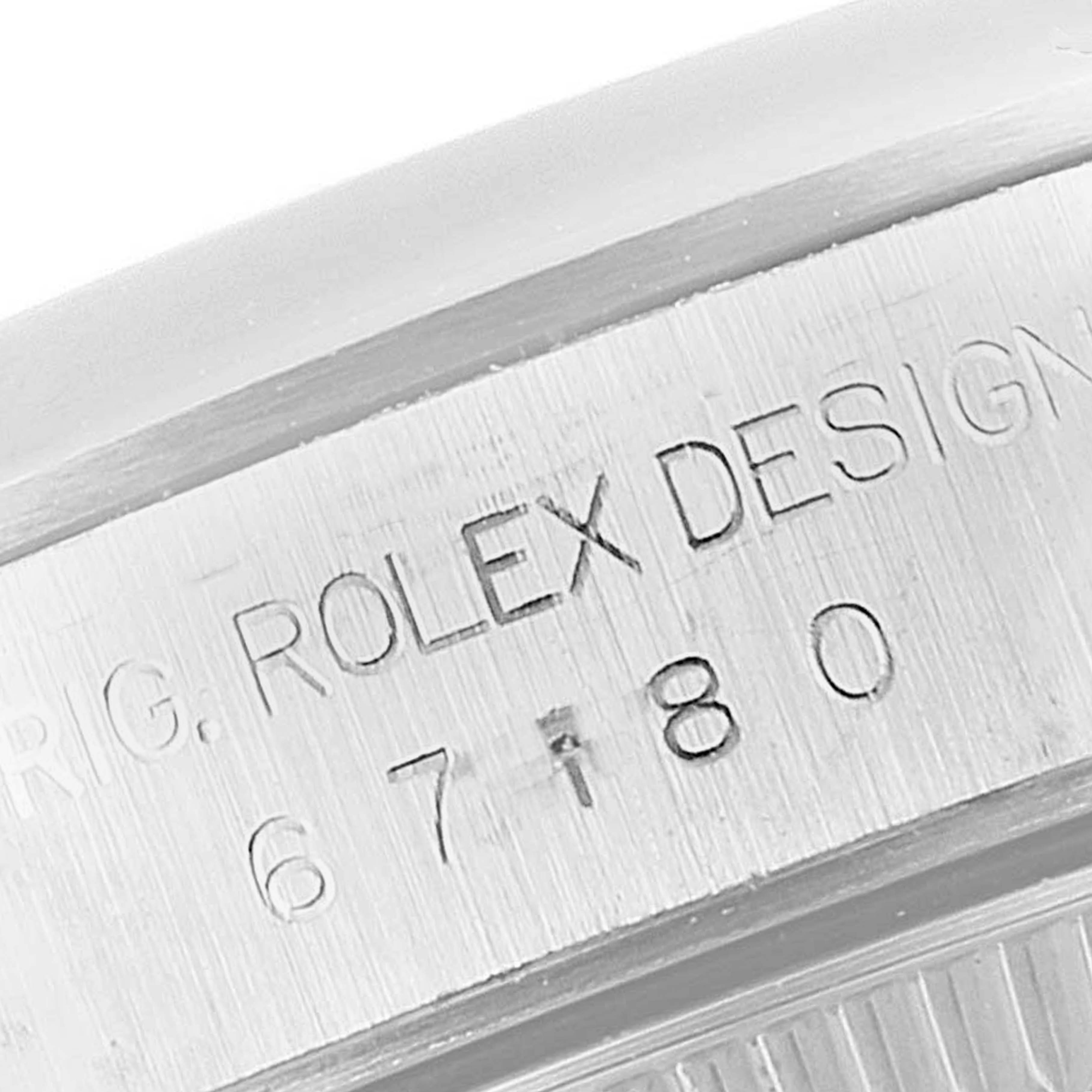 This is a close-up image of the engraved text on the case back of a Rolex Oyster Perpetual 67180 Women's Stainless Steel Black Dial 67180 Women's Stainless Steel Black Dial watch.
