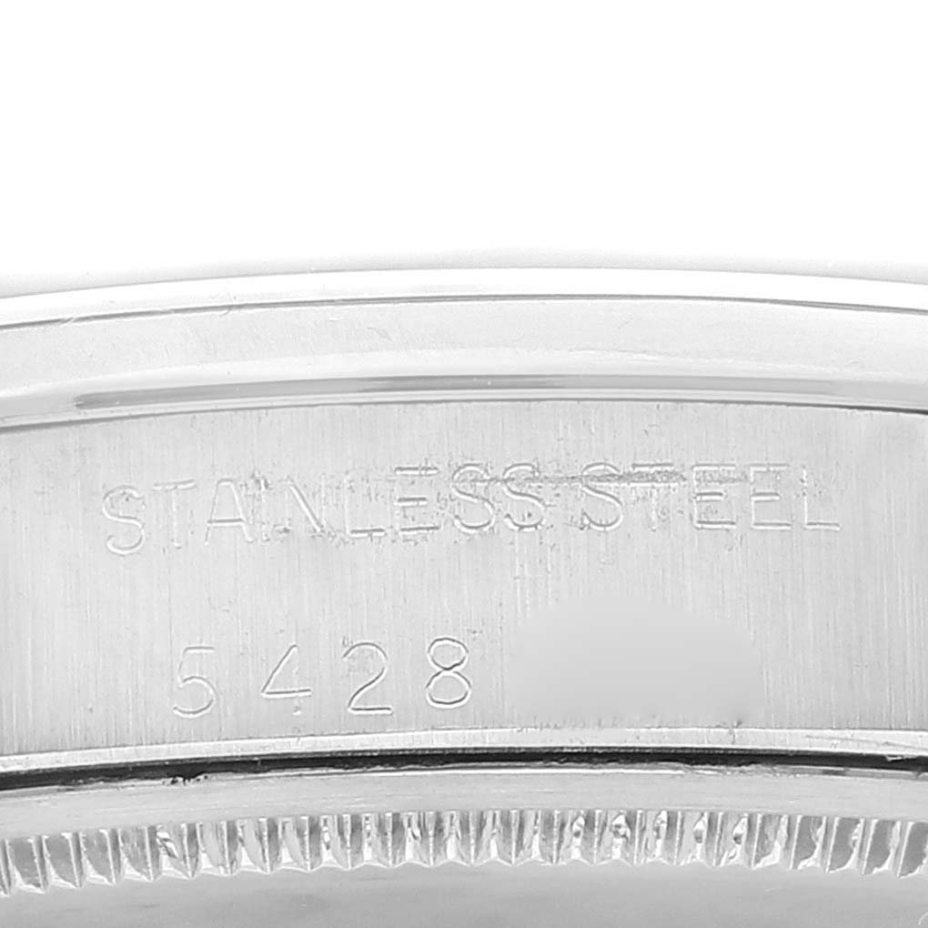This image shows a close-up view of the serial number and "stainless steel" engraving on the casing of a Rolex Vintage Collection 6694 Men's Stainless Steel Silver Dial 6694 Men's Stainless Steel Silver Dial model watch.