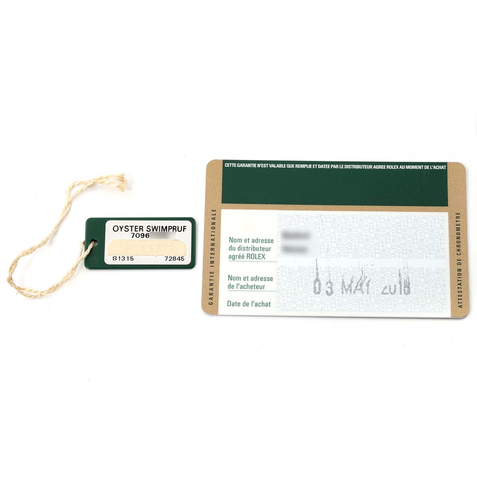 This image shows an Oyster Swimpruf tag and an international warranty card for the Rolex Pearlmaster 81315 Women's Rose Gold Mother of Pearl Dial 81315 Women's Rose Gold Mother of Pearl Dial watch, viewed from above.