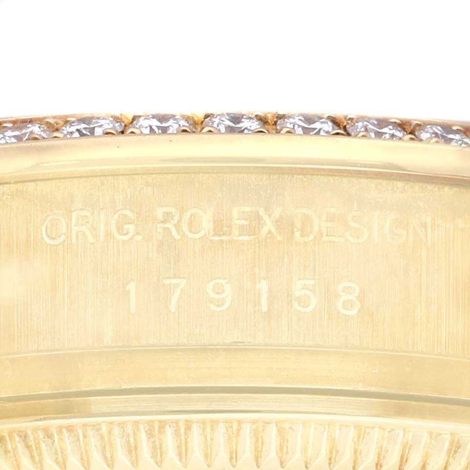 This image shows a close-up of the serial number and part of the bezel with diamonds on a Rolex President 179158 Women's Yellow Gold Champagne Dial 179158 Women's Yellow Gold Champagne Dial model watch.