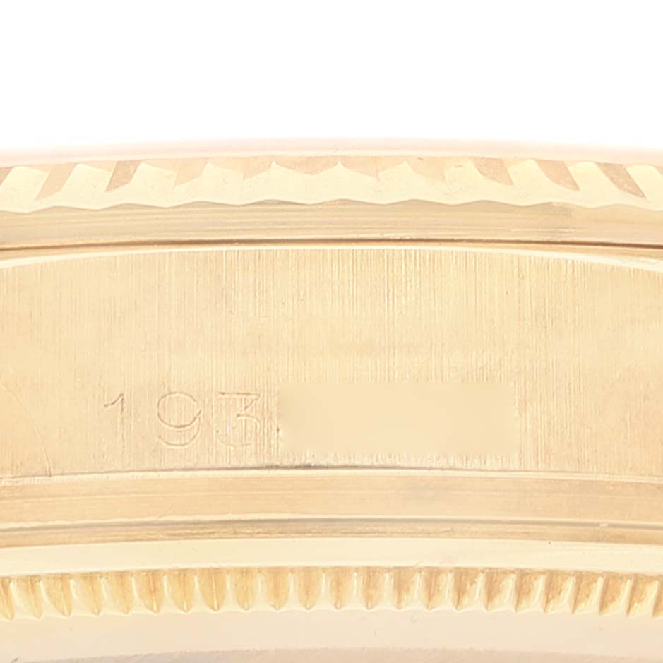 This image shows a close-up of the side of a Rolex Vintage Collection 1803 Men's Yellow Gold Champagne Dial 1803 Men's Yellow Gold Champagne Dial watch, highlighting part of its engraving and serrated bezel.