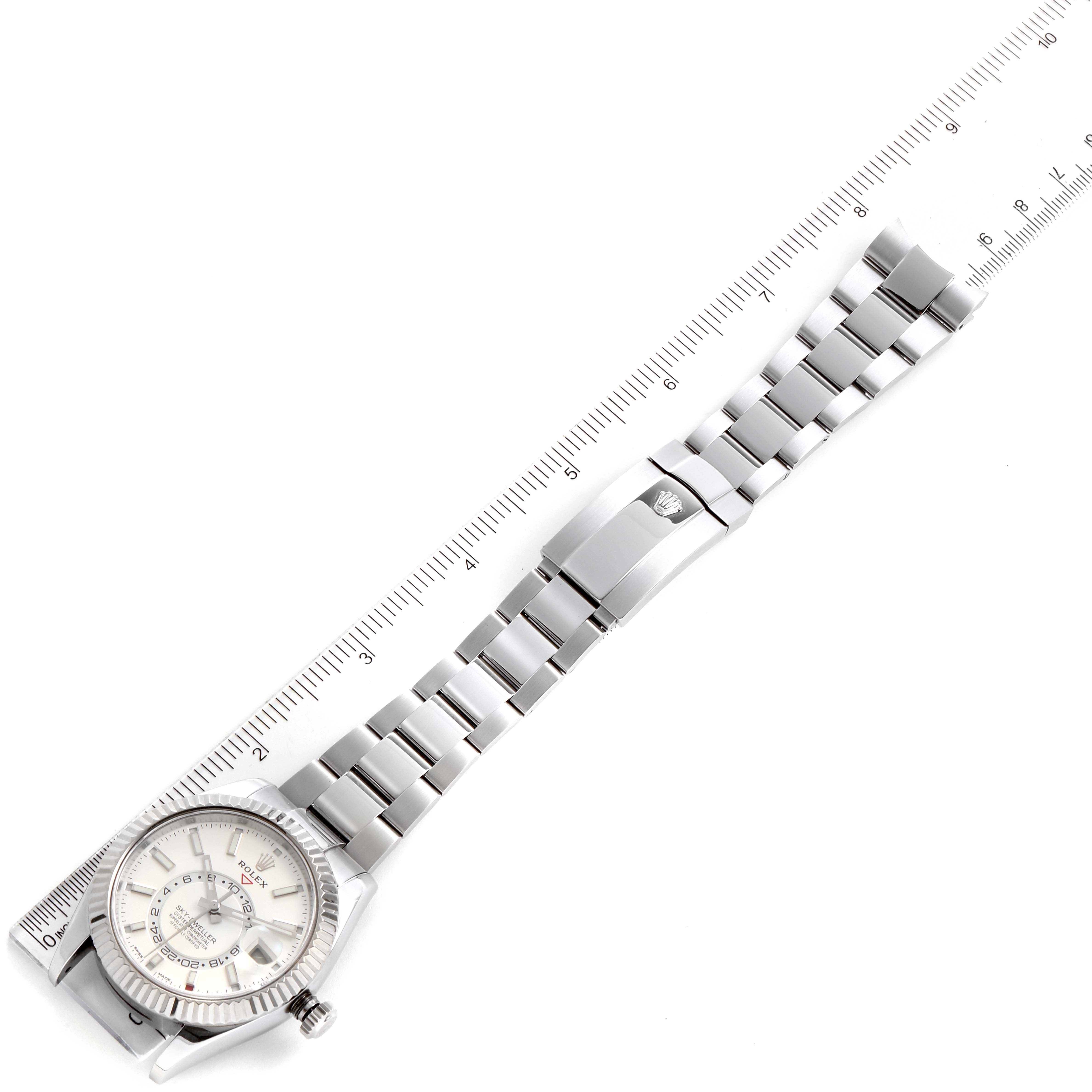 The Rolex Sky-Dweller 326934 Men's Stainless Steel White Dial 326934 Men's Stainless Steel White Dial watch is shown from the top angle, displaying its face, bracelet, and clasp with a ruler measuring the length.