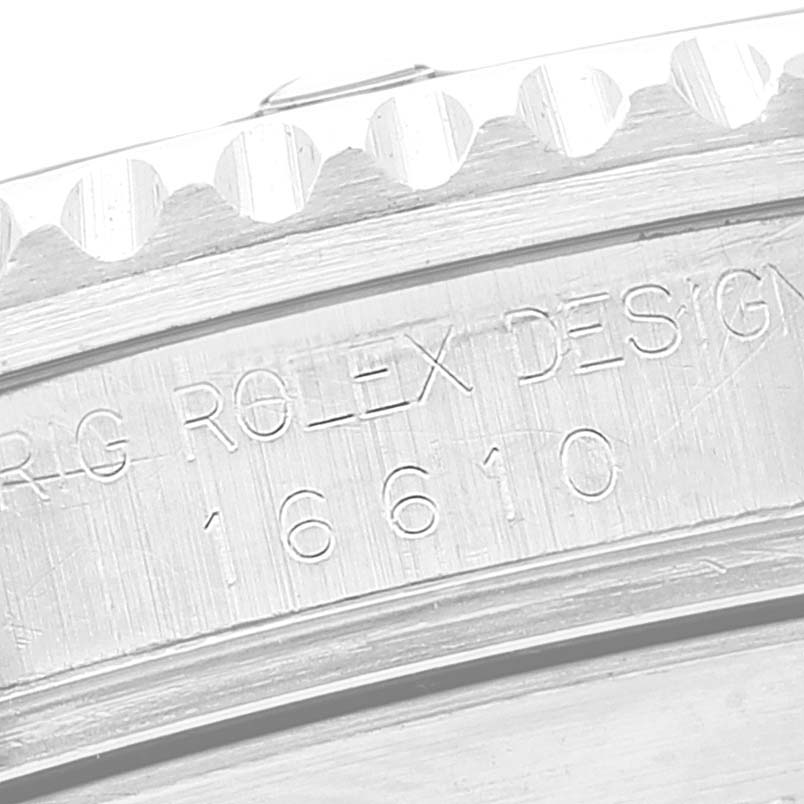 The image shows a close-up of the case side engraving of a Rolex Submariner 16610 Men
s Stainless Steel Black Dial 16610 Men
s Stainless Steel Black Dial model 16610, focusing on the bezel edge.