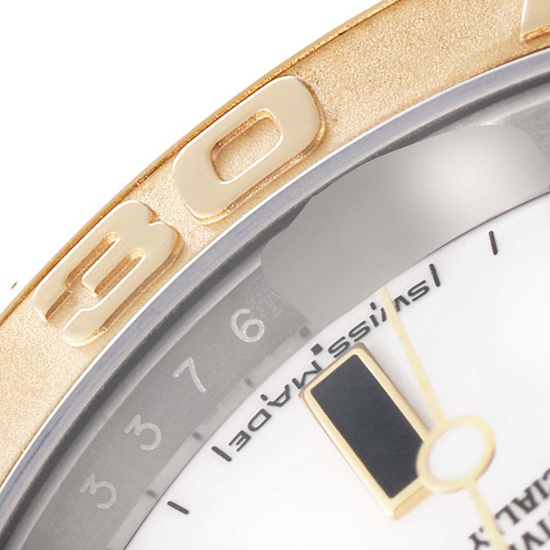This close-up image of a Rolex Yacht-Master 16623 Men
s Steel and Gold (two tone) White Dial 16623 Men
s Steel and Gold (two tone) White Dial watch shows parts of the bezel, dial, and indices.