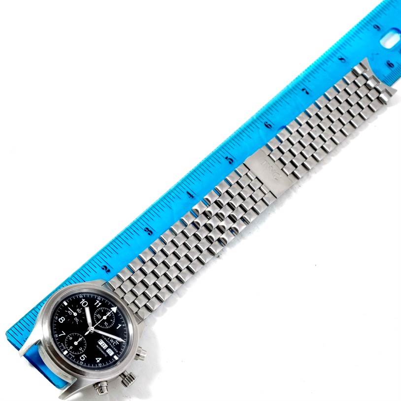 The image shows an IWC Pilot IW370607 Men's Stainless Steel Black Dial IW370607 Men's Stainless Steel Black Dial model watch and its stainless steel bracelet, measured against a blue ruler.