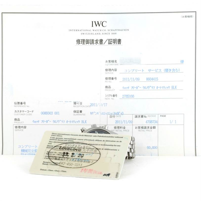 The image shows the back and part of the bracelet of an IWC Pilot IW370607 Men's Stainless Steel Black Dial IW370607 Men's Stainless Steel Black Dial watch along with documentation and a warranty card.