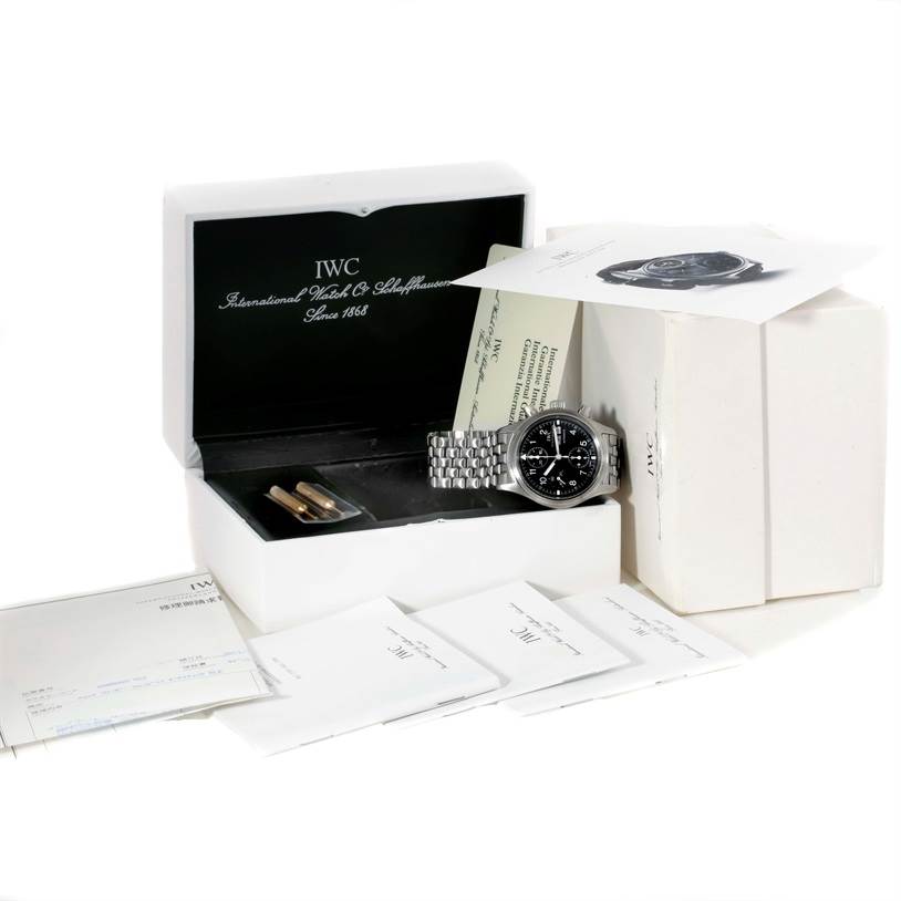 The IWC Pilot IW370607 Men's Stainless Steel Black Dial IW370607 Men's Stainless Steel Black Dial model watch is shown from an angled top view, with its box, documentation, and additional accessories.