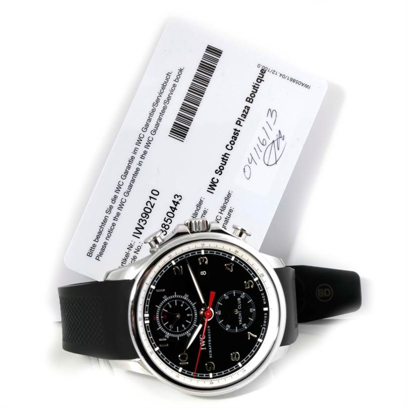 The IWC Portuguese IW390210 Men's Stainless Steel Black Dial IW390210 Men's Stainless Steel Black Dial watch model is shown from a top-down angle, featuring its black dial and black strap, accompanied by a warranty card.