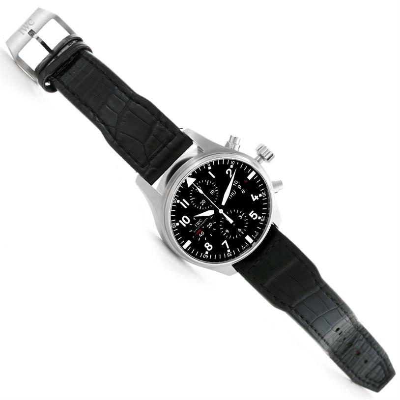 The image shows an IWC Pilot IW377701 Men's Stainless Steel Black Dial IW377701 Men's Stainless Steel Black Dial model watch from a top-down view, showcasing the dial, case, and strap.